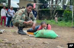 New volunteer Mekdess Muluneh Asayehegn, right, and others receive training to become potential reinforcements for pro-government militias or military forces, in a school courtyard in Gondar, in the Amhara region of northern Ethiopia Aug. 24, 2021.
