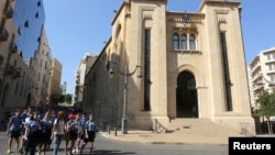 FILE - Students walk outside the parliament building in downtown Beirut, Lebanon.