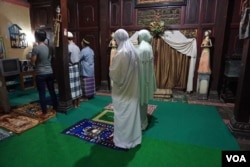 Ibu Shinta (mukena hijau) dan waria lainnya melaksanakan shalat maghrib di Pesantren al-Fatah di Yogyakarta. (K. Varagur/VOA)