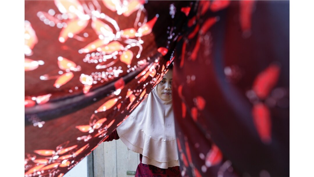 A mangrove batik worker dries a batik cloth in Klaces village, Cilacap, Central Java province, Indonesia, November 4, 2021. Picture taken November 4, 2021. REUTERS/Ajeng Dinar Ulfiana