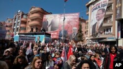 People listen to Mehmet Ozhaseki, the candidate of Turkey's ruling Justice and Development Party, AKP, and opposition Nationalist Movement Party, MHP, for Ankara Metropole, during a rally by MHP in Kecioren district, in Ankara, Turkey, Sunday, March 10, 2019. 