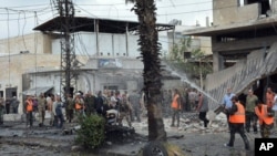 FILE - Syrian security forces and firefighters gather at an explosion in the central city of Homs, Syria, May 23, 2017. Syrian state TV reported that an explosion in the central city of Homs has killed several people.
