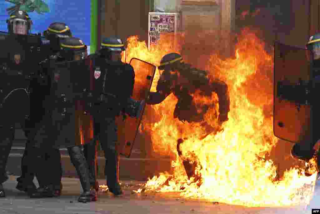 در جریان تظاهرات در مقابل اصلاحات جنجالی قانون کار در شهر پاریس فرانسه، پولیس ضد شورش در میان شعله های آتش بم آتشین که از سوی تظاهر کننده گان پرتاب شده است.