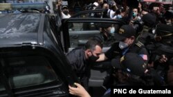 El exministro Alejandro Sinibaldi desciende de un auto tras ser extraditado desde Italia. Foto cortesía PNC de Guatemala.