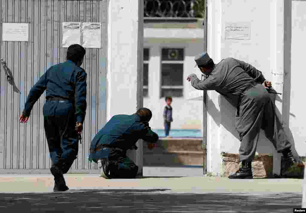 Afghan policemen try to rescue a child at the site of a suicide attack on a Shi&#39;ite Muslim mosque in Kabul, Aug. 25, 2017.