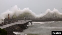 Large waves crash against the Kalk Bay harbour wall during severe weather in Cape Town