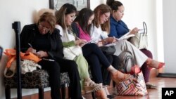 FILE - Women fill out job applications at a JobNewsUSA job fair in Miami Lakes, Fla., Jan. 30, 2018. Friday morning the Labor Department will release its report on March employment. Economists forecast that 185,000 jobs were added in March.