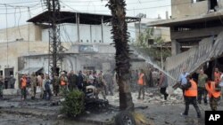 Foto yang diambil tanggal 23 Mei 2017 dan dirilis oleh kantor berita resmi Suriah, SANA, tampak pasukan keamanan Suriah dan pemadam kebakaran berkumpul di lokasi ledakan, di pusat kota Homs, Suriah (foto: SANA via AP)