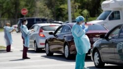 Healthcare workers screen people at a drive-through COVID-19 testing site, March 20, 2020, at the Doris Ison Health Center in Miami, Florida.