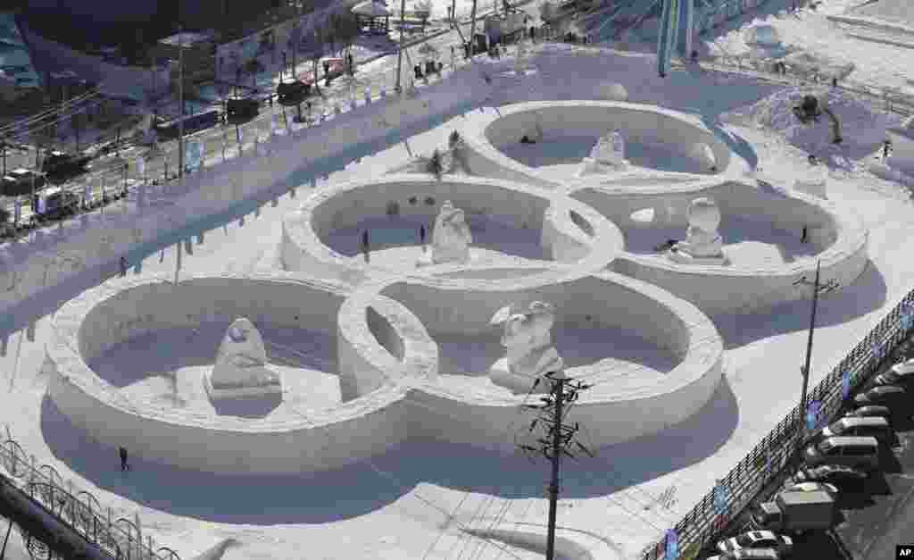 Visitors tour near the snow sculpture in the shape of the Olympic rings displaying at the Daegwanryung Snow festival in Pyeongchang, South Korea. Pyeongchang is the host city of the 2018 Olympic and Paralympic Winter Games to be held in February 2018.