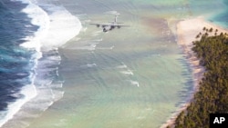 FILE - A plane flies along the coast of Micronesia, Dec. 8, 2015. Micronesia, along with the Cook Islands, Fiji, Kiribati, the Marshall Islands, Micronesia, Nauru, Niue, Palau, Papua New Guinea, Samoa, the Solomon Islands, Tonga, Tuvalu and Vanuatu have expressed concern about rising sea levels most scientists agree is caused by global warming.