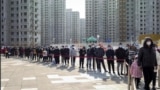 Residents wearing face masks to protect from the coronavirus line up for the coronavirus test during a mass testing in north China's Tianjin municipality, Sunday, Jan. 9, 2022. Tianjin, a major Chinese port city near the capital Beijing, began mass testin