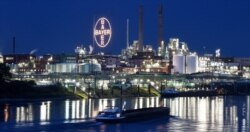 FILE - A ship passes the main chemical plant of German Bayer AG in Leverkusen, Germany, August 9, 2019. The company has agreed to settlements in cases involving its glyphosate-based weedkiller Roundup.