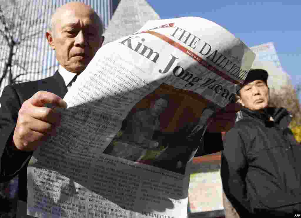 Người đàn ông ở khu thương mại Ginza, Tokyo đọc phụ trang tiếng Anh của tờ báo Nhật Bản nói về cái chết của Kim Jong Il, 19 tháng 12.