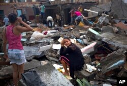 A woman cries amid the rubble of her home, destroyed by Hurricane Matthew in Baracoa, Cuba, Oct. 5, 2016.