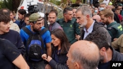 La Reina Letizia (C) y el Rey Felipe VI de España reaccionan mientras los residentes enojados los abuchean durante su visita a Paiporta, en la región de Valencia, este de España, el 3 de noviembre de 2024, después de devastadoras inundaciones mortales.