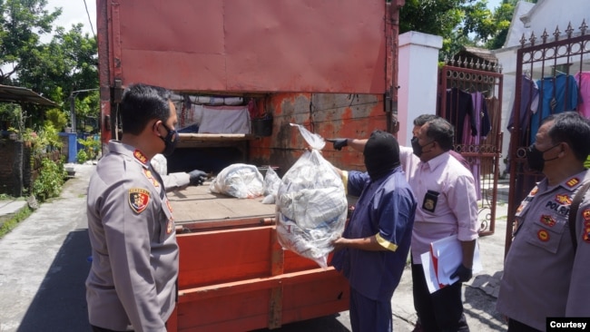 Petugas polisi dari Kepolisian Resort Sukoharjo menunjukkan kantong-kantong yang digunakan untuk menyimpan 53 anjing yang akan dikirim ke pedagang kuliner daging anjing di Jawa Tengah, pada 25 November 2021. (Foto: Courtesy Polres Sukoharjo)
