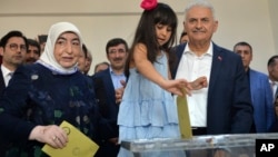Бинали Йылдырым (справа) на избирательном пункте с супругой и внучкой