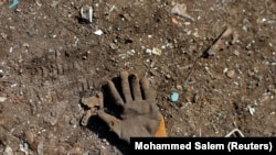 A glove left behind by a Palestinian worker is seen on the ground at a metal waste junkyard. The picture was taken January 25, 2021. REUTERS/Mohammed Salem