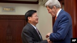 Lao Foreign Minister Thongloun Sisoulith, left, welcomes U.S. Secretary of State John Kerry, before their meeting at the Ministry of Foreign Affairs in Vientiane, Laos, Monday, Jan. 25, 2016. Kerry is in Laos on the third leg of his latest round-the-world diplomatic mission, which will also take him to Cambodia and China. (AP Photo/Jacquelyn Martin, Pool)