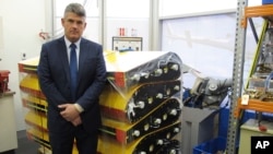 FILE - Peter Foley, Australian Transport Safety Bureau director of Malaysian Flight 370 search operations, stands beside a stack of replica wing flaps, Aug. 18, 2016, at the bureau's headquarters in Canberra, Australia. 