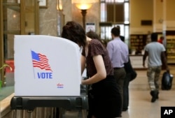 People cast their votes at a polling station inside the Enoch Pratt Free Library's central library branch in Baltimore, April 26, 2016.