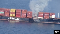 In this photo released by the Canadian Coast Guard and received by AFP on October 24, 2021, smoke is seen rising from the side of the container ship Zim Kingston off Canada's Pacific coast.