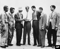 Seven atom bomb scientists look over a roentgenometer at the site of the test atom bomb explosion, Sept. 13, 1945. (From left) Dr. Kenneth T. Bainbridge, Harvard; Dr. Joseph G. Hoffmann, University of Buffalo; Dr. J. Robert Oppenheimer, California; Dr. Louis H. Hempelmann, Washington; Dr. Victor Weisskoff; Dr. Robert F. Bacher, Cornel University; and Dr. Richard W. Dooson, California.