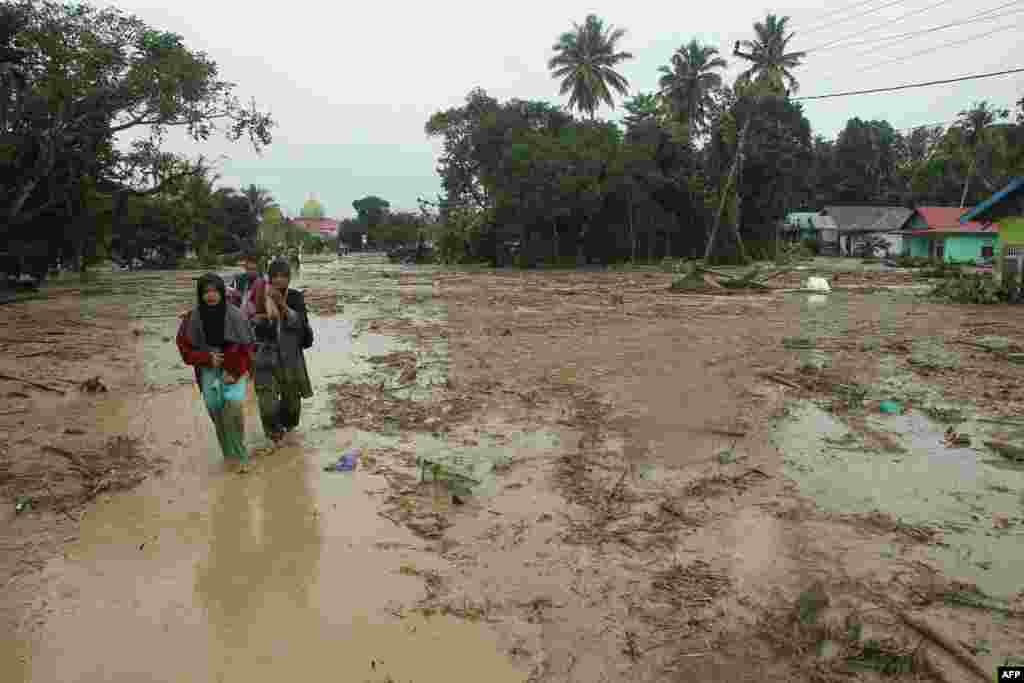 인도네시아 사우스 술라웨시의 마을에 계절성 폭우로 홍수가 발생한 후 주민들이 대피하고 있다. 