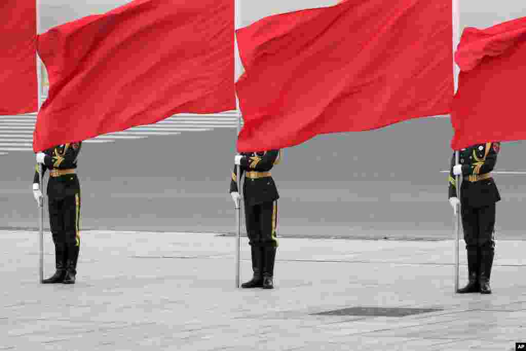 Members of the honor guard hold red flags as they wait for the arrival of visiting Peruvian President Pedro Pablo Kuczynski during a welcome ceremony outside the Great Hall of the People in Beijing, China.