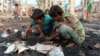 Children look at debris after a fire outbreak in Rohingya refugee camp, in Cox's Bazar, Bangladesh, Jan. 14, 2021.