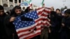 Demonstranti cepaju američku zastavu na protestu zbog vazdušnog udara u Iraku u kome je ubijen general Revolucionarne garde Kasem Sulejmani u Teheranu, 3. januara 2020.