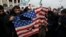 FILE - Protesters deface an American flag during an anti-U.S. rally over the U.S. airstrike in Iraq that killed Iranian Revolutionary Guard Gen. Qassem Soleimani, in Tehran, Iran, Jan. 3, 2020.