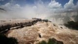 Tourists visit the Iguazu Falls walkway as it reopens to the public after being temporarily closed due to the high water flow from recent heavy rains, in Foz do Iguacu, Parana state Brazil, Dec. 11, 2024.