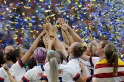 The U.S. team celebrates with the trophy after winning the Women's World Cup final soccer match between US and the Netherlands, at the Stade de Lyon, in Decines, outside Lyon, France, July 7, 2019.