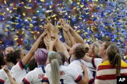 The U.S. team celebrates with the trophy after winning the Women's World Cup final soccer match between US and the Netherlands, at the Stade de Lyon, in Decines, outside Lyon, France, July 7, 2019.