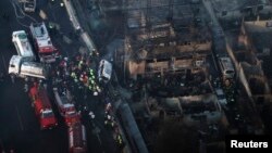 Firefighters and rescue workers stand amidst the rubble of destroyed houses after the explosion of a gas tanker truck in Ecatepec, on the outskirts of Mexico City, May 7, 2013.