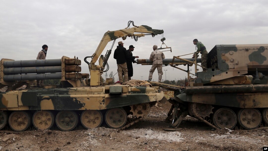 Serdadu-serdadu Irak mengisi roket ke peluncur multitabung selama pertempuran melawan militan Islamic State untuk merebu kembali Mosul University di sisi timur Mosul, Irak (13/1). (foto: AP Photo/ Khalid Mohammed)