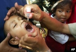 Seorang anak laki-laki diberikan vaksin polio di Jakarta. (Foto: AP/Tatan Syuflana)