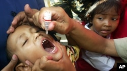 Mtoto mvulana akipokea chanjo ya polio katika mji wa Jakarta, Indonesia, Nov 30, 2005.
