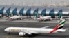 FILE- In this Wednesday, March 22, 2017 file photo, an Emirates plane taxis to a gate at Dubai International Airport at Dubai International Airport in Dubai, United Arab Emirates. The Middle East's biggest airline says it is reducing flights to the United States because of a drop in demand caused by tougher U.S. security measures and attempts by the Trump administration to ban travelers from a number of Muslim-majority nations. (AP Photo/Adam Schreck, File) c