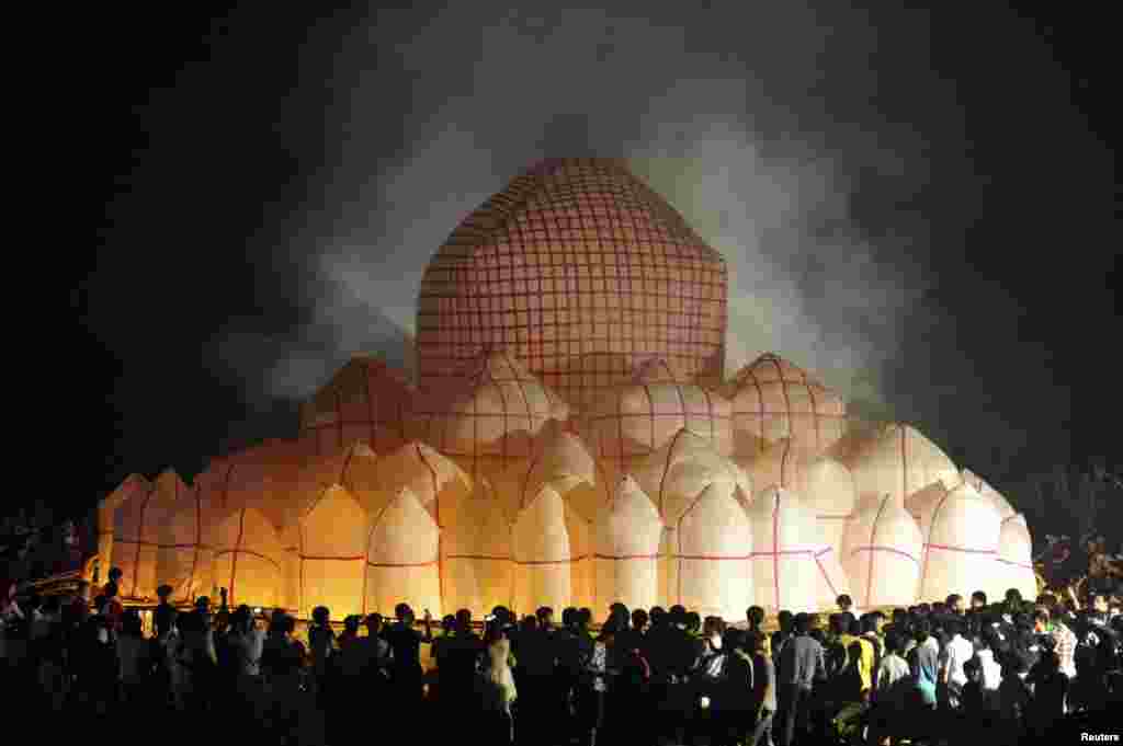 People launch a 30-meter-diameter paper lantern at Xiapo village, Qionghai, Hainan province, China. The lantern, made of 72 smaller lanterns, was designed for a local ritual ceremony to mark the Chinese Hungry Ghost Festival, also known as Yu Lan, a traditional Chinese festival on the 15th night of the seventh month of the Chinese calendar.