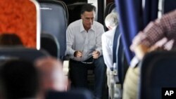 Republican presidential candidate and former Massachusetts Governor Mitt Romney talks with Senator Rob Portman who has also been his debate practice partner, on his campaign charter plane en route to Denver, Colorado, October 1, 2012.