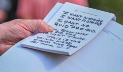 U.S. President Donald Trump holds what appears to be a prepared statement and handwritten notes after watching testimony by U.S. Ambassador to the European Union Gordon Sondland.