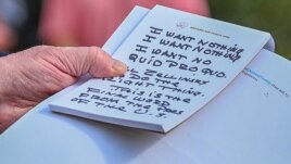 U.S. President Donald Trump holds what appears to be a prepared statement and handwritten notes after watching testimony by U.S. Ambassador to the European Union Gordon Sondland.