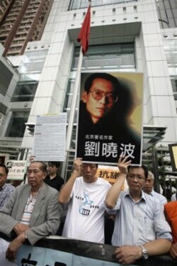 FILE - ​ Pro-democracy lawmakers and activities hold picture of Liu Xiaobo during protest outside China's liaison office in Hong Kong