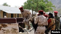 Soldiers carry a body after a missile attack on a military parade during a graduation ceremony for newly recruited troopers in Aden, Yemen Aug. 1, 2019. 