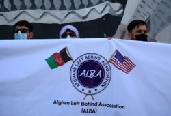 Former Afghan interpreters hold placards during a demonstrations against the US government, in front of the US Embassy in Kabul, Afghanistan, Friday, June 25, 2021.