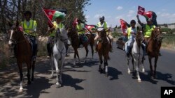 Jordanian men ride horses and fly their national flags during a rally celebrating the upcoming royal wedding, in Amman, Jordan, May 30, 2023.