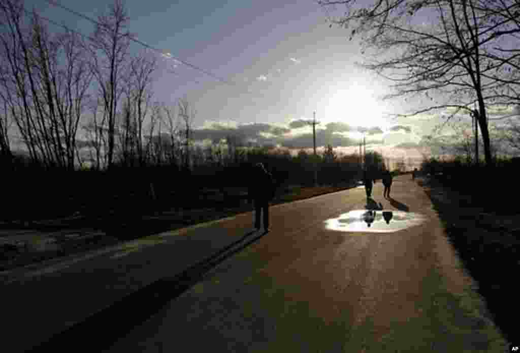 Tourists head to the bus after walking around the ghost town of Pripyat. (VOA Photo/D. Markosian)